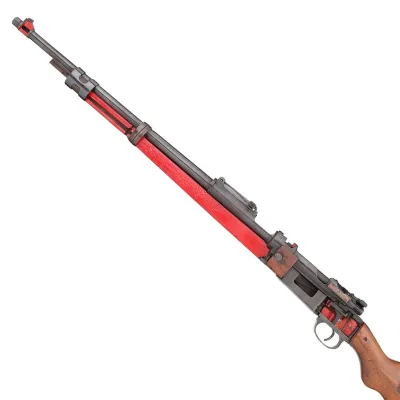 A cross section of a long barrelled rifle where the wood has been stripped away and the interior is exposed in metal and red paint