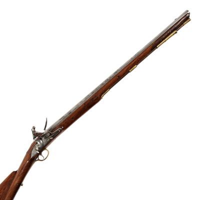 A long barrelled carbine with distinctive two tone buttstock, in wood with exposed steel barrel and brass trim