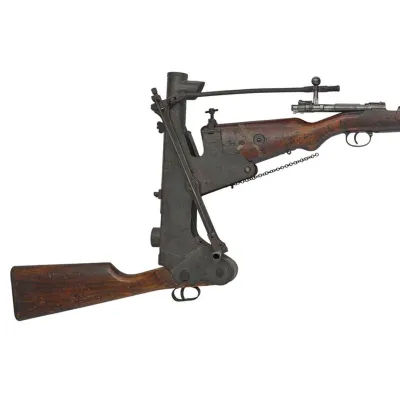 A metallic device attached to the wooden buttstock of a rifle where a secondary wooden buttstock is positioned half a foot below