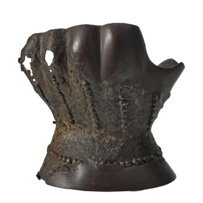 An hourglass shaped piece of metal to be worn over the hand and wrist