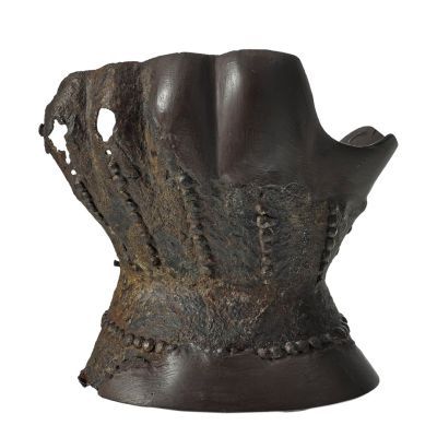 An hourglass shaped piece of metal to be worn over the hand and wrist