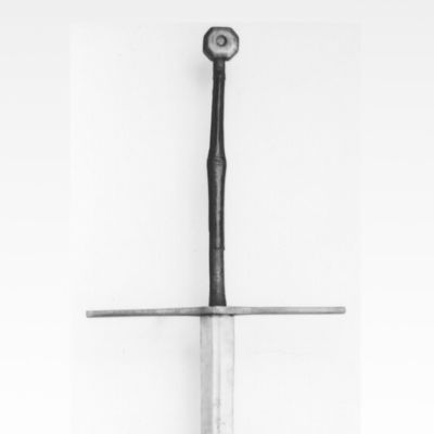 Steel hilted long sword with octagonal pommel, stylised engravings, a wooden grip covered in leather, and straight cross guard