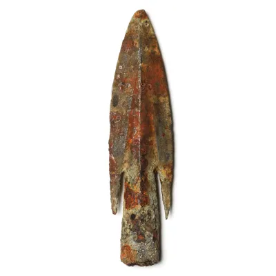 A metal arrowhead with tapering socket for wooden shaft and brazed barbs.