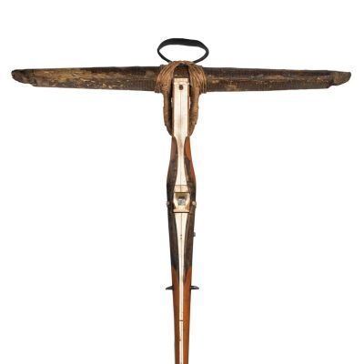 An ornate crossbow made with wood, horn or ivory, and metal. The construction forms a T shape.