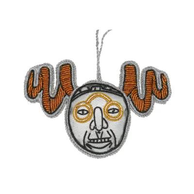 A hanging decoration in a circle with a face on and twisted horns