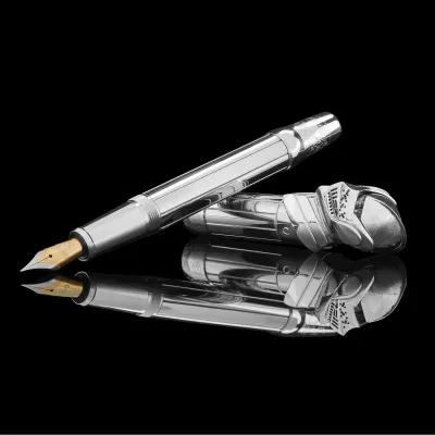 Chrome‑finished fountain pen with a gold nib resting beside its cap, which is sculpted in the form of an armoured knight’s helmet, reflected on a glossy black surface