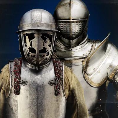 Seventeenth-century harquebusier's armour of James II of England, silvered and decorated with a faceguard bearing the royal arms held by lion and unicorn; armour of Henry VIII stands behind.