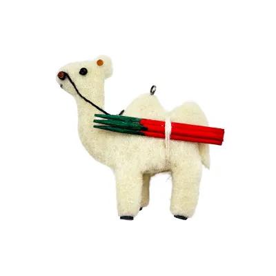 Small felt camel ornament facing left, cream wool body, black stitched reins, carrying red and green stick bundle on its side