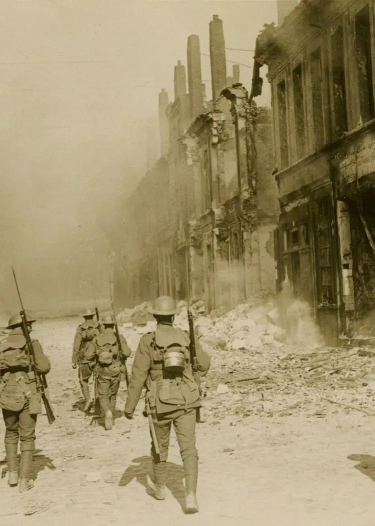 First World War British soldiers walk through a rubble strewn street 1917-1918