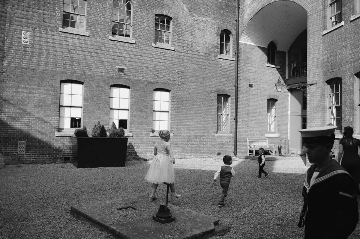 black and white picture of 3 children in the courtyard of For Nelson on a sunny day