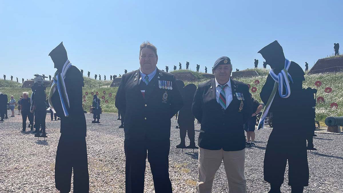 Two Falklands war veterans place scarves on life size silhouettes of military personal