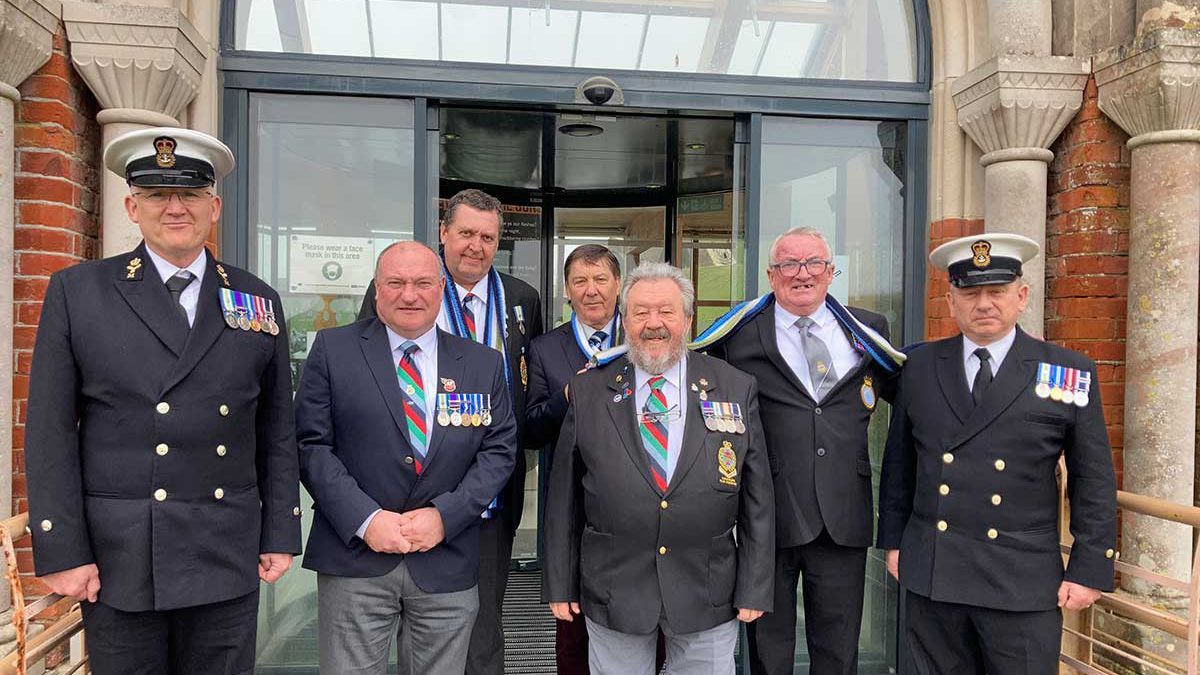 seven military veterans posing for a picture at Fort Nelson
