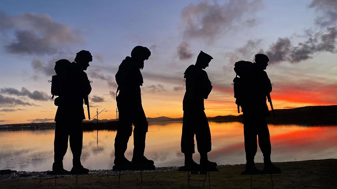 4 military silhouettes with a sunset in the background