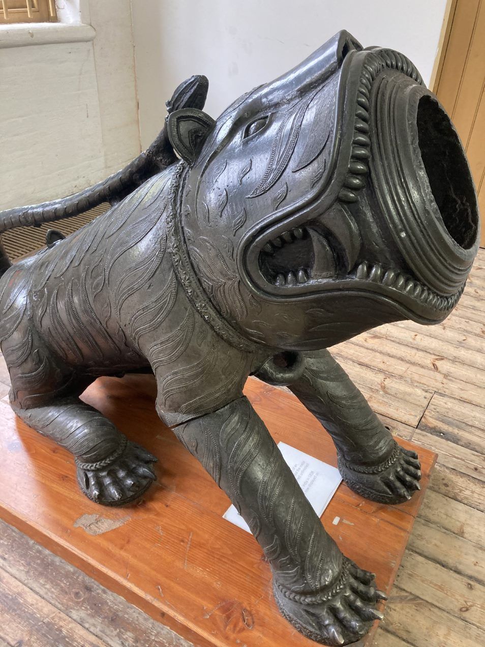 a mortar cast in bronze in the form of a sitting tiger