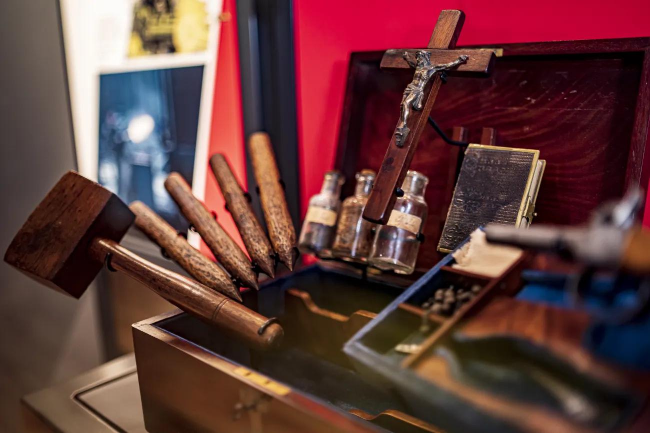 A sinister looking vampire killing kit containing a wooden mallet and four stakes, bottles of garlic, silver and holy water, a crucifix and bible