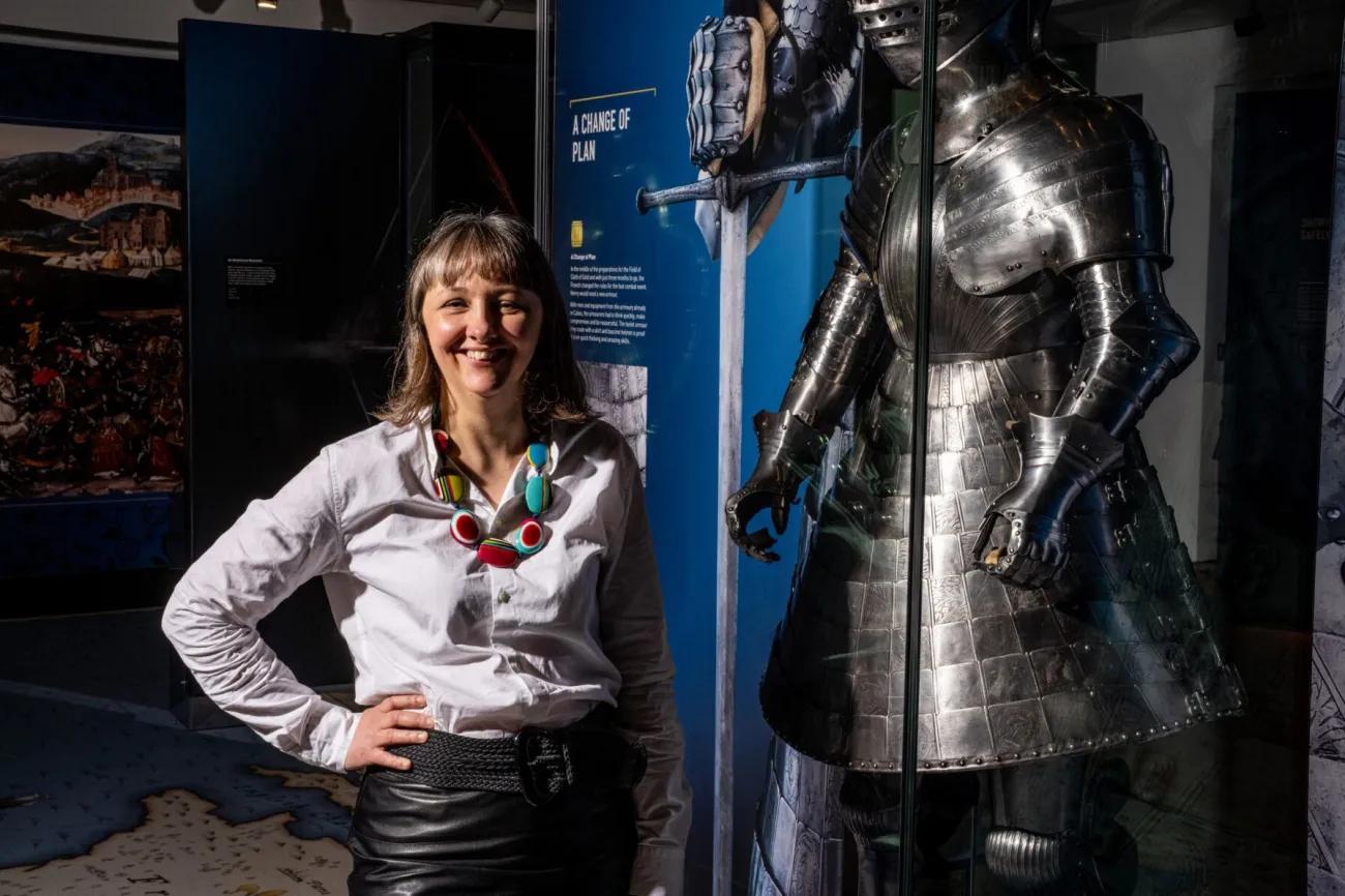 Florence Symington standing next to a full suit of armour in the museum