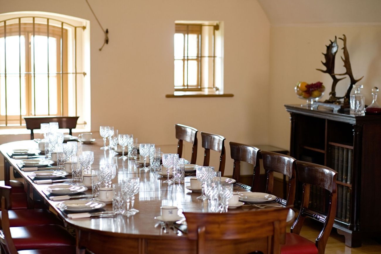 Large vintage table and chairs setup with plates, cutlery and crystal glasses