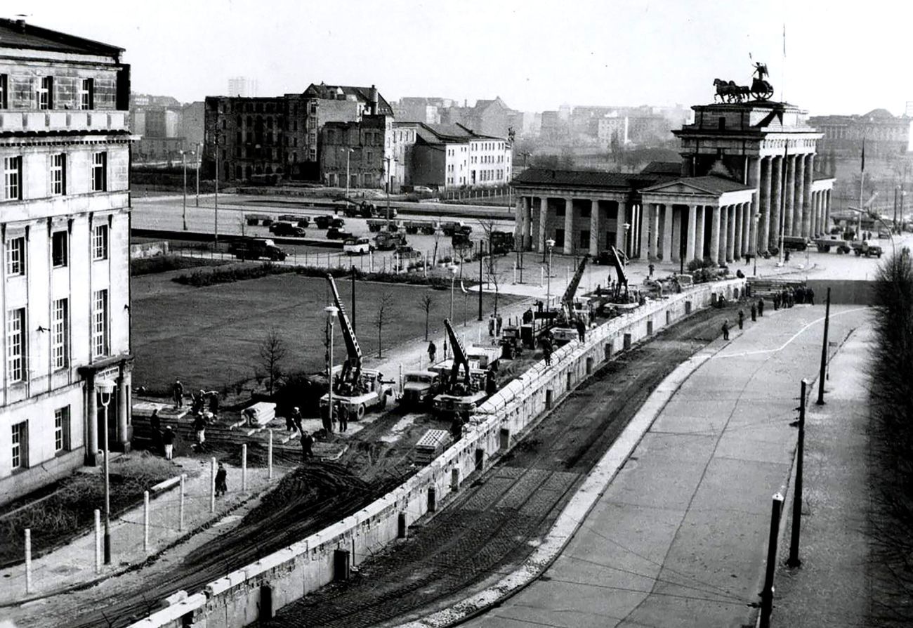 A black and white image from the early 1960s showing the building of the Berlin Wall in the direction of the Brandenburg Gate. 