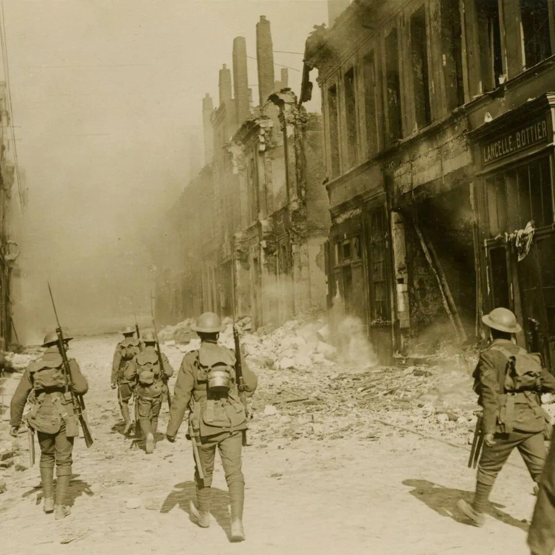 First World War British soldiers walk through a rubble strewn street 1917-1918