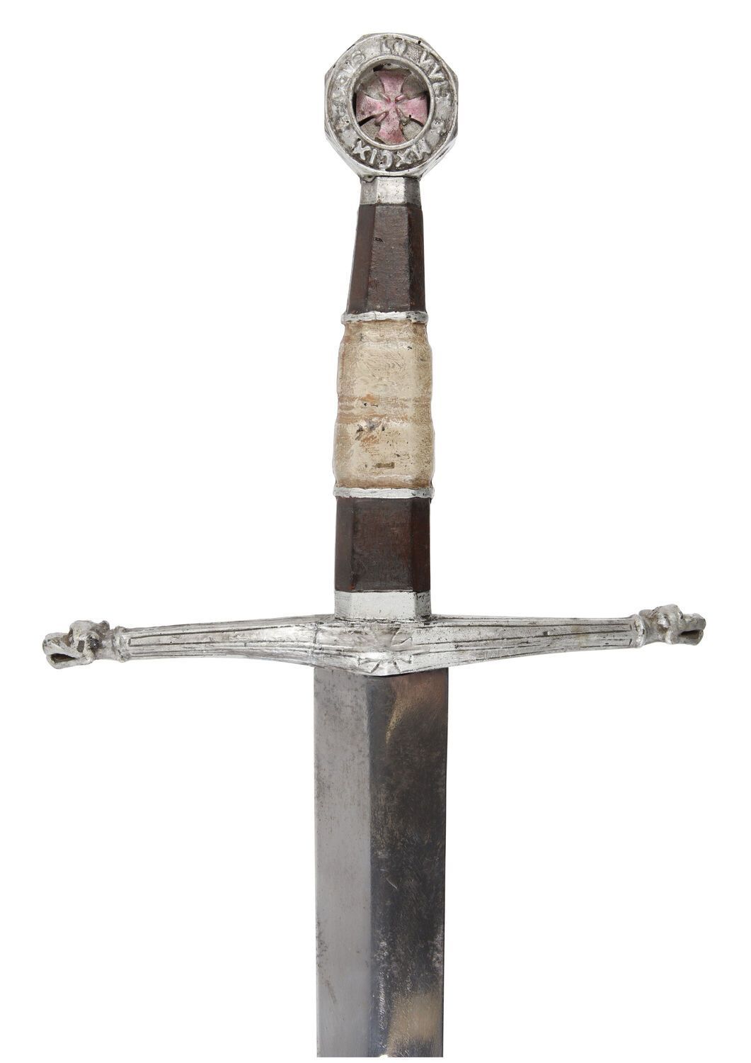 A decorated hilt of a sword with the blade facing down