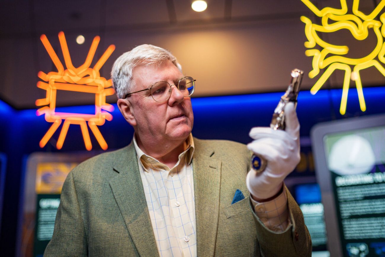 Curator Mark Murray-Flutter holding a pistol for RE:Loaded exhibition promotion