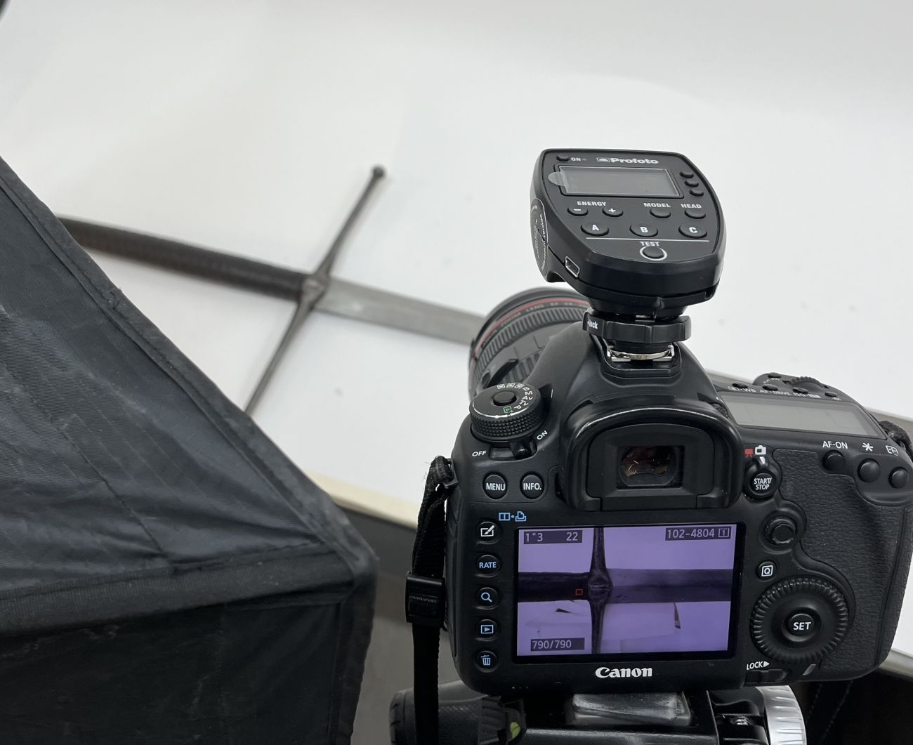 Camera with image of sword on the rear screen with sword on a table in the background