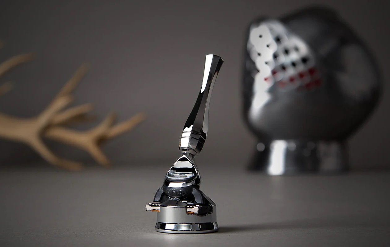 Royal armouries shaver collaboration with wilde and harte showing razor in foreground and helmet in the background.