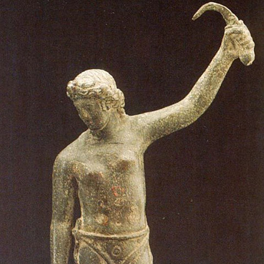 A faded photograph of a topless female warrior holding aloft a sica or curved sword