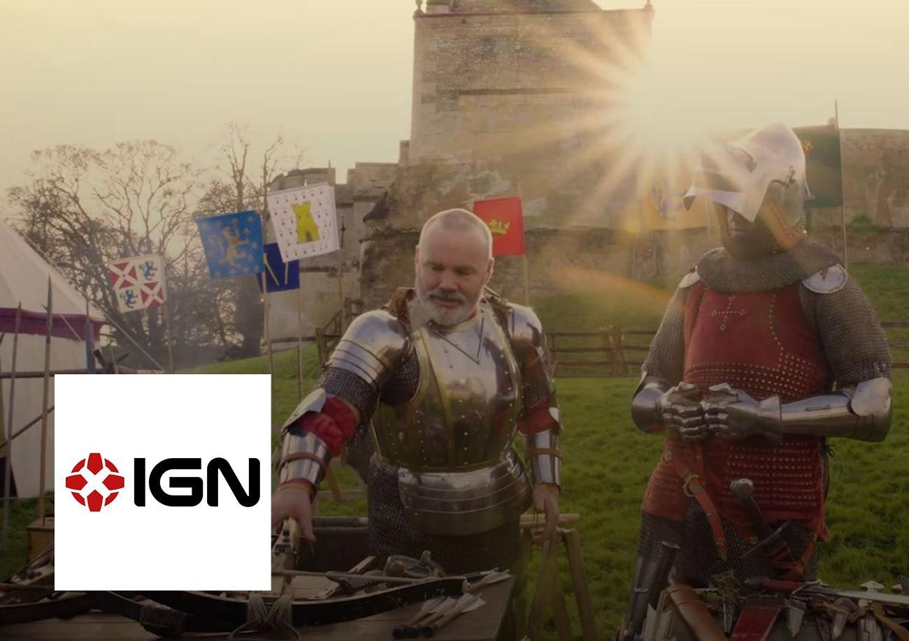 two knights standing in front of a castle examining medieval weapons with the IGN logo bottom left