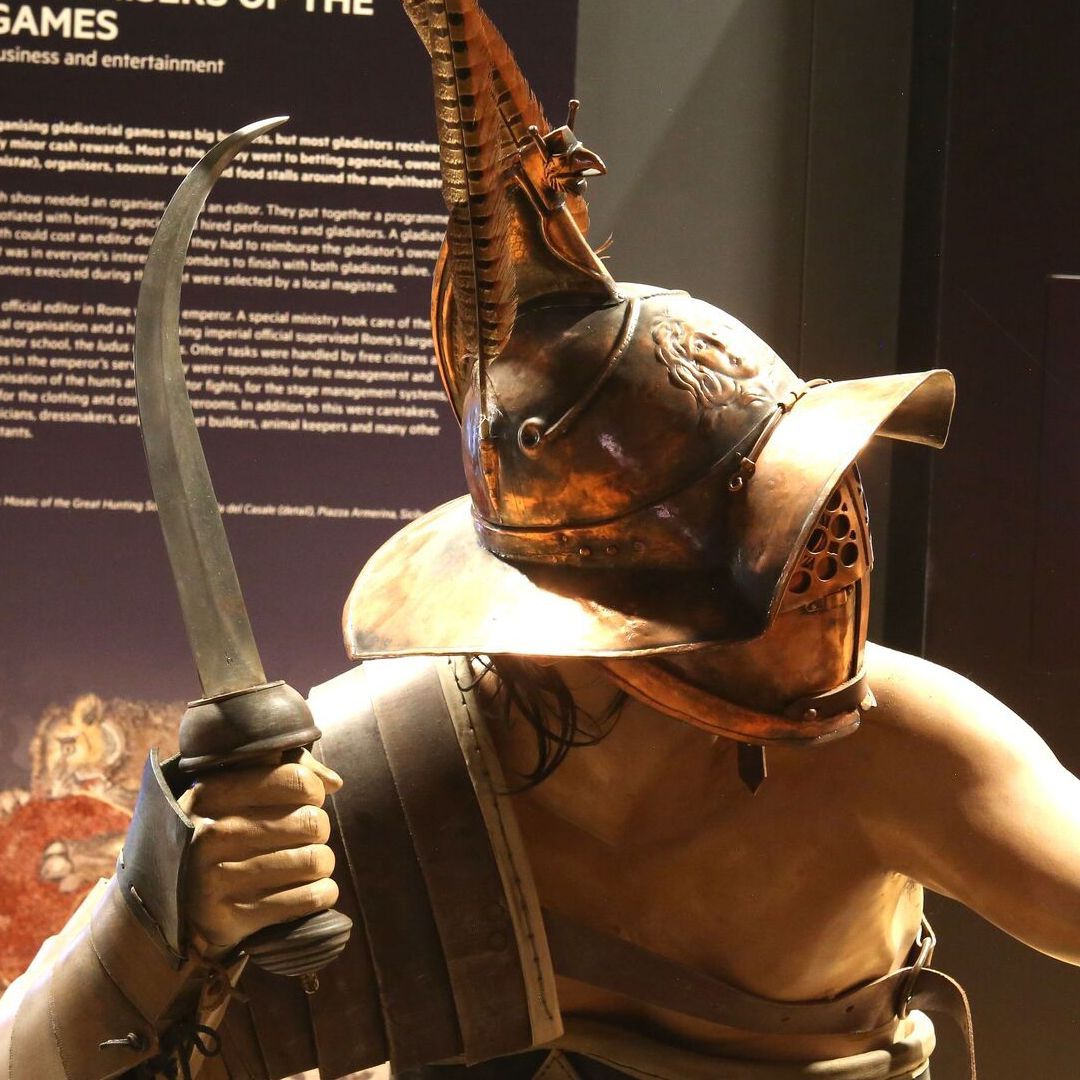 A mannequin of a Thraex gladiator with distinctive broad rimmed helmet and curved sword or sica