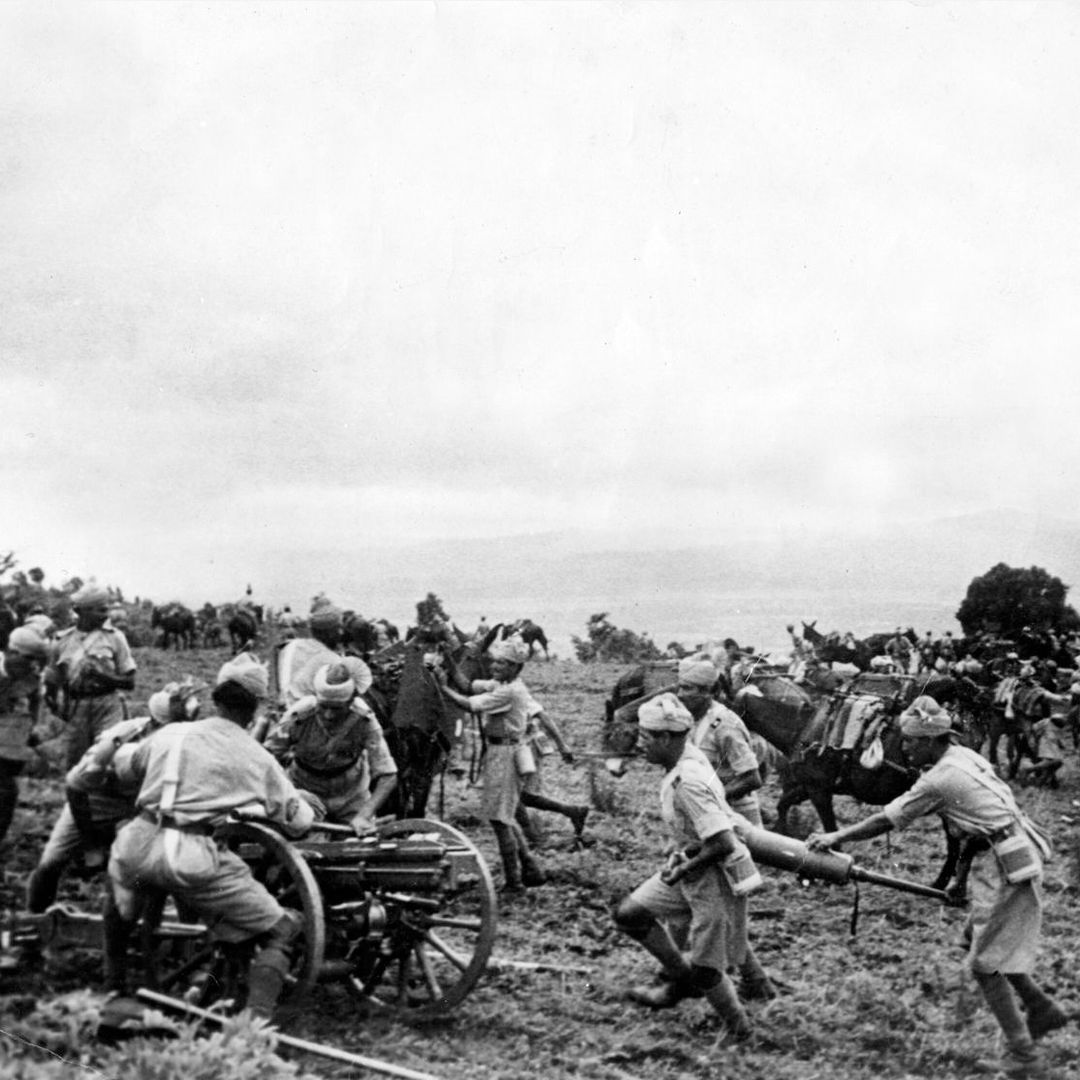 A black and white photo of Indian soldiers during the Second World War moving field guns into position