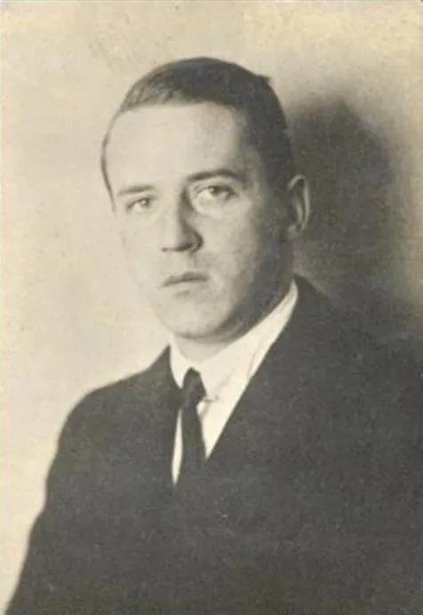 A grainy sepia tone photograph of a clean shaven man in a suit 