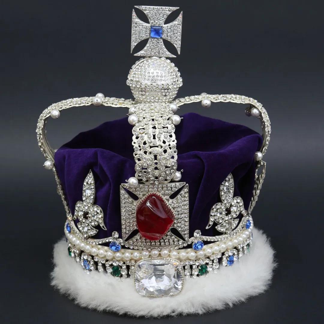 A jewelled crown in white gold with a cross atop, rimmed in purple velvet and white ermine
