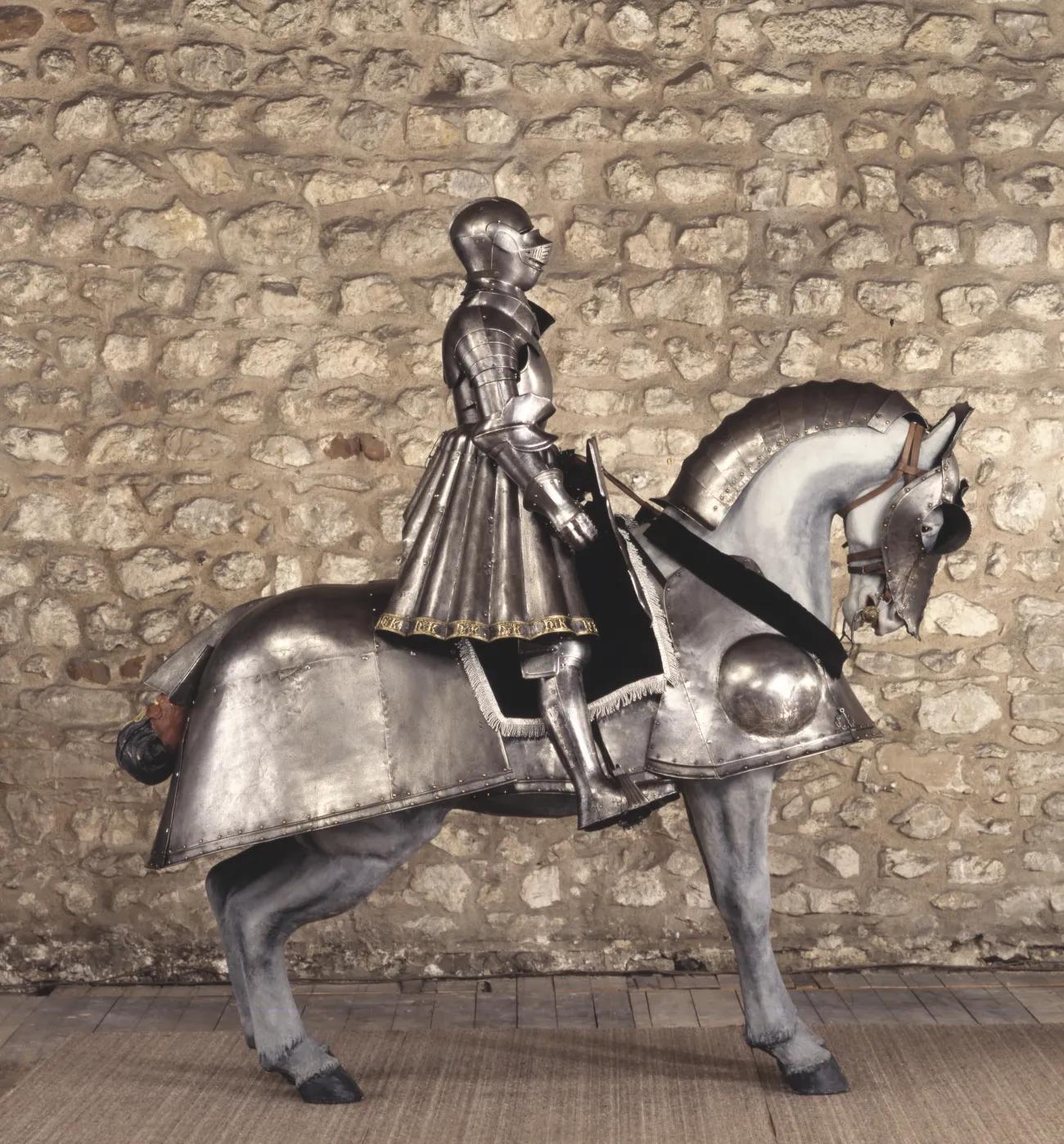 A suit of steel armour with gold edging sat atop a horse mannequin with plate armour