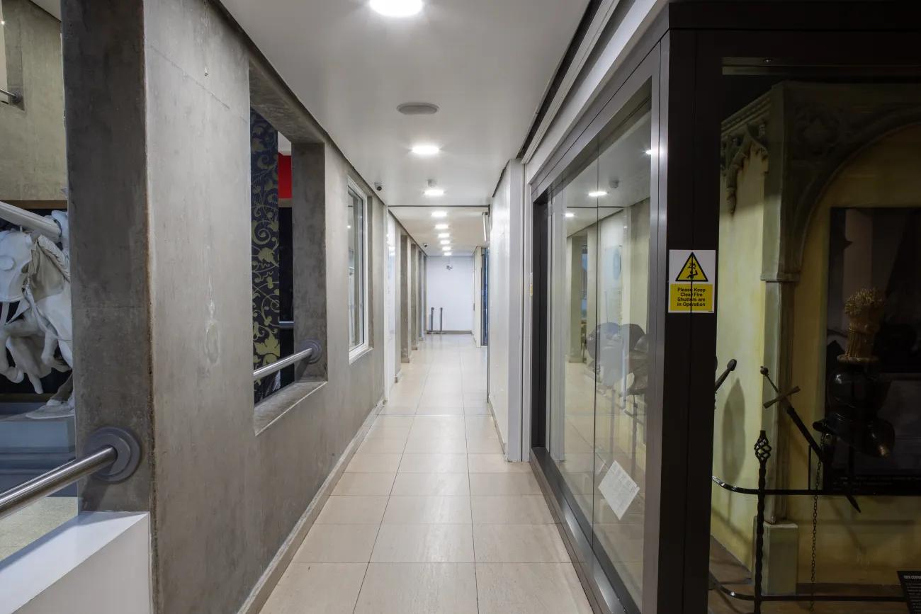 A grey corridor leading down to a blank space at the far end.