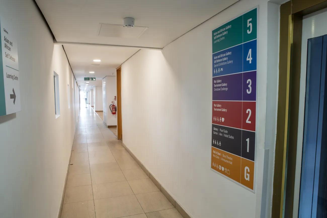 A long corridor leading from a lift to a balcony bridge