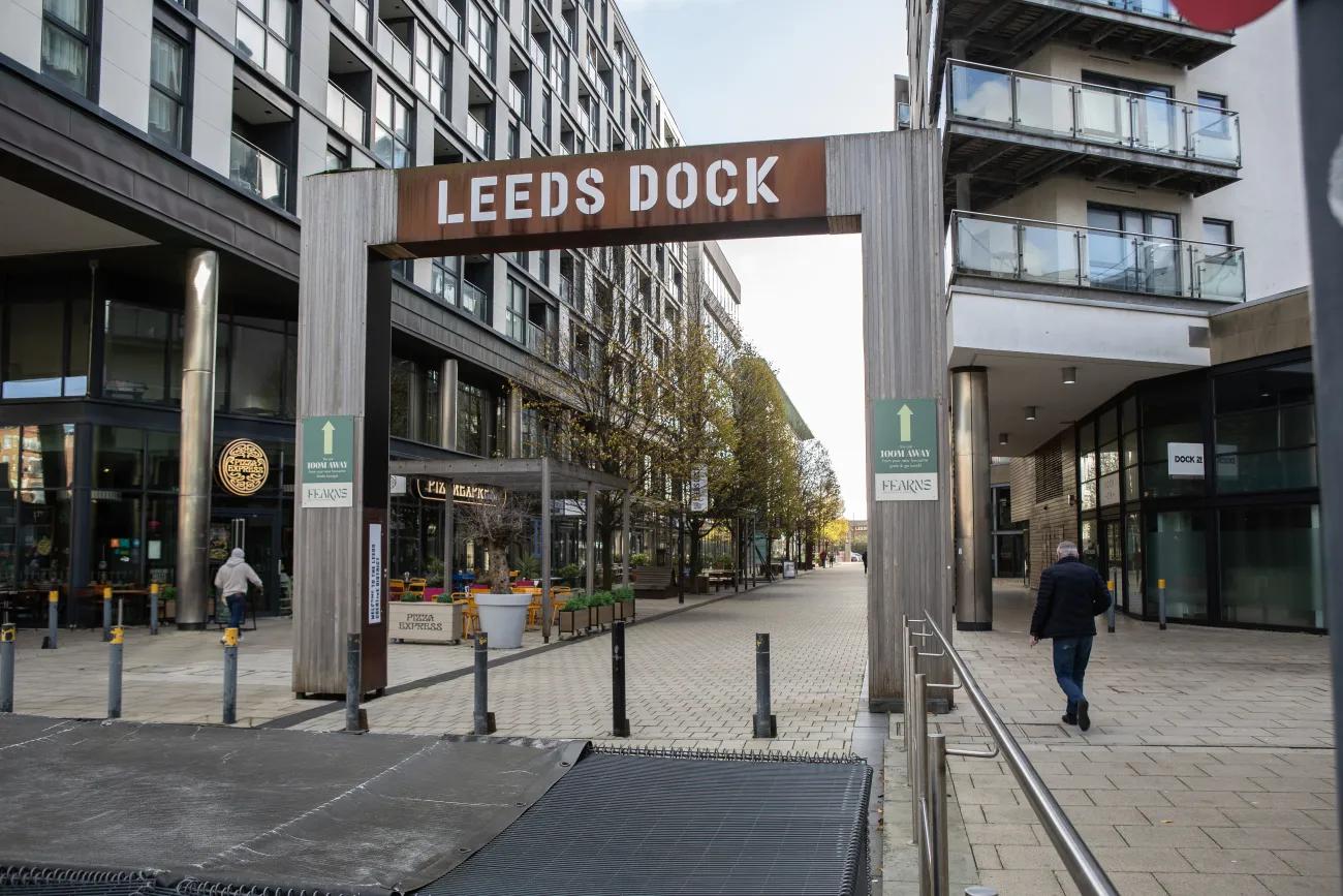 A wood and steel arch with the words Leeds Dock across