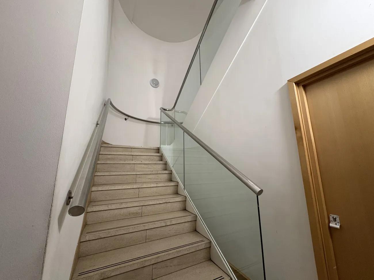 A white stairwell with steps leading up and around to the next floor