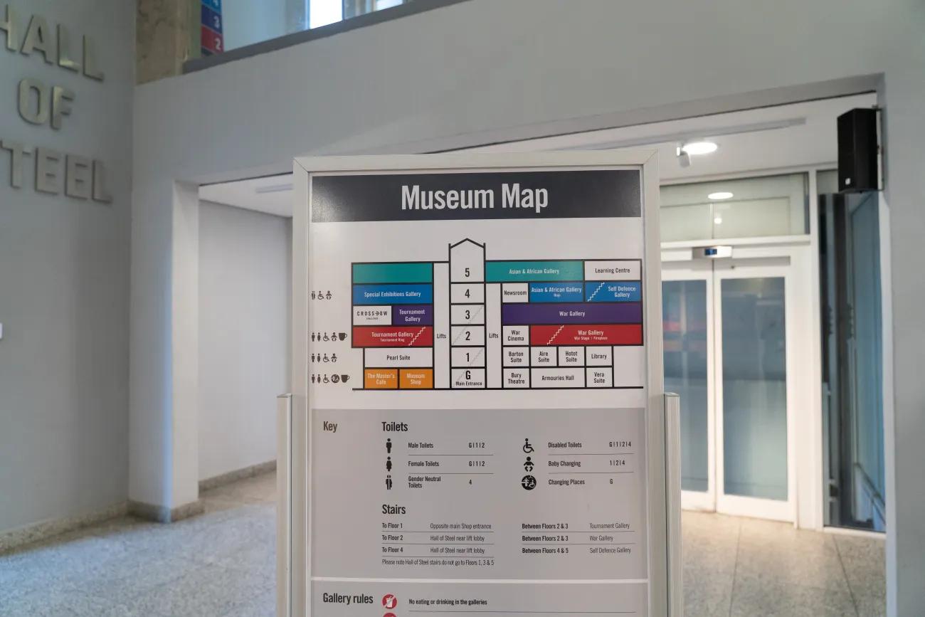 A board in front of a row of lifts displaying in colour the different floors of the Royal Armouries Museum