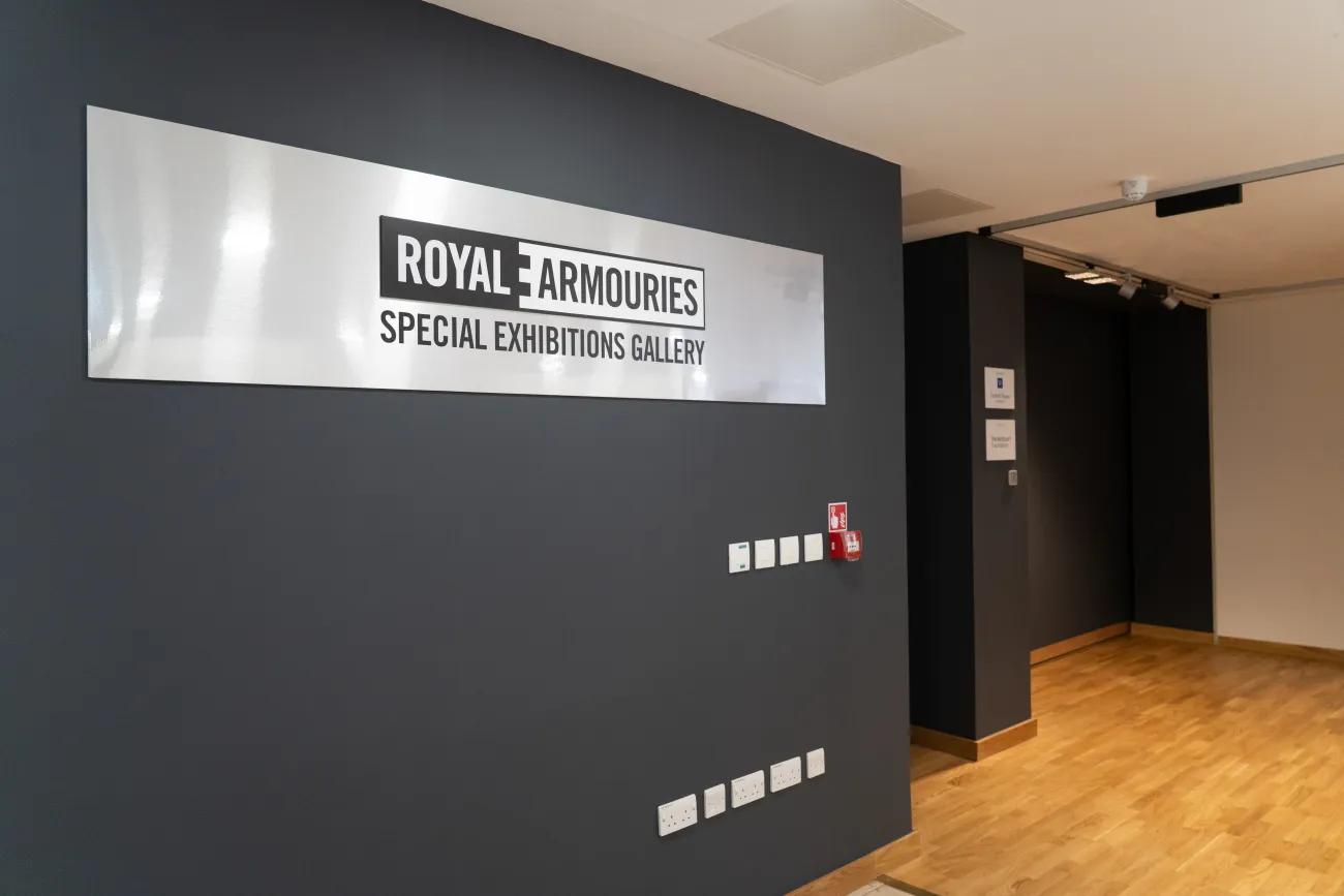 A black wall is marked by a steel banner announcing the Royal Armouries Special Exhibition