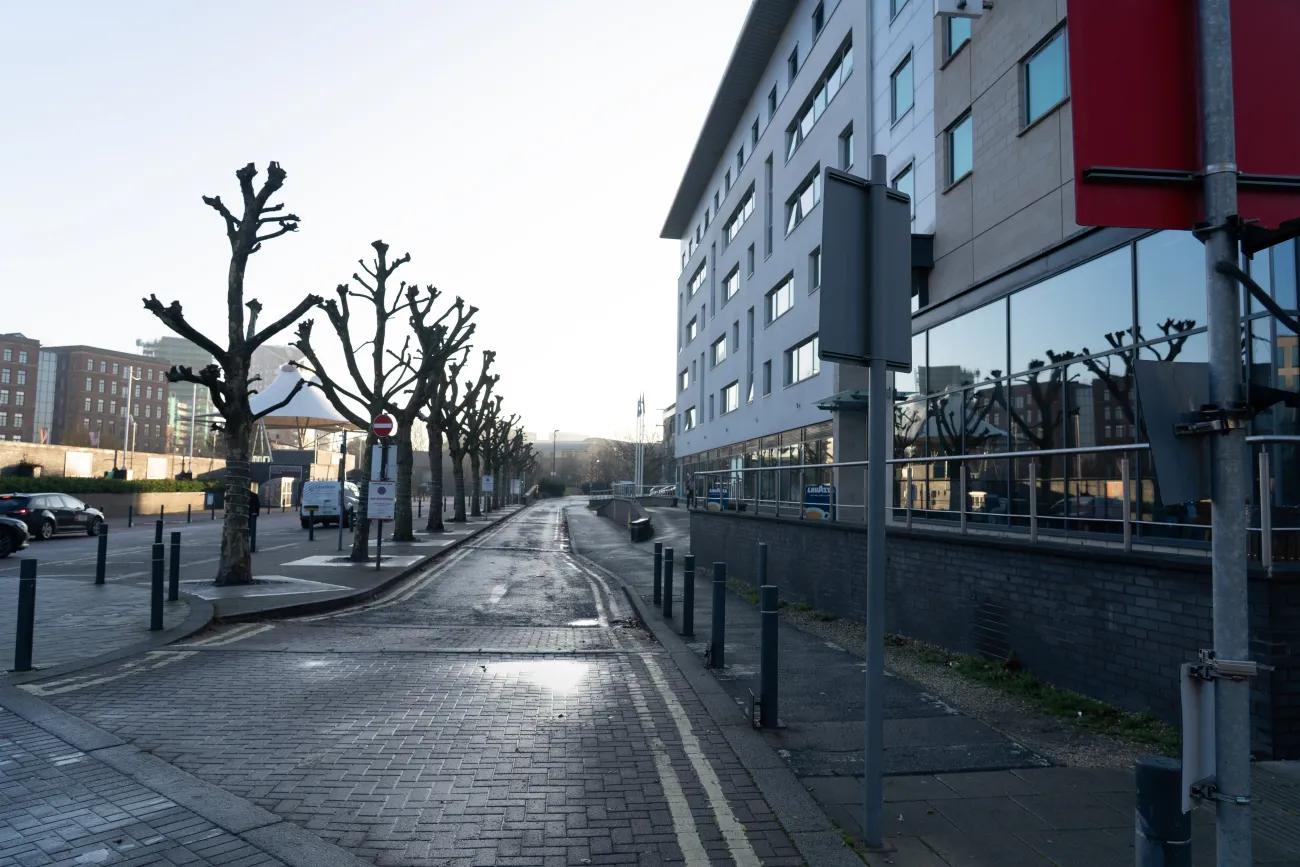 A photo of a road leading down past a hotel towards a car park