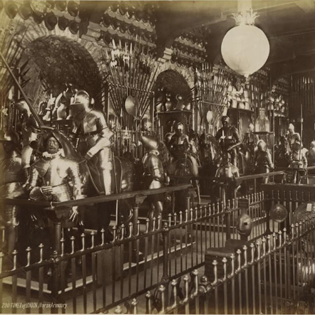 A sepia tone photograph of a display of armour from the 19th century