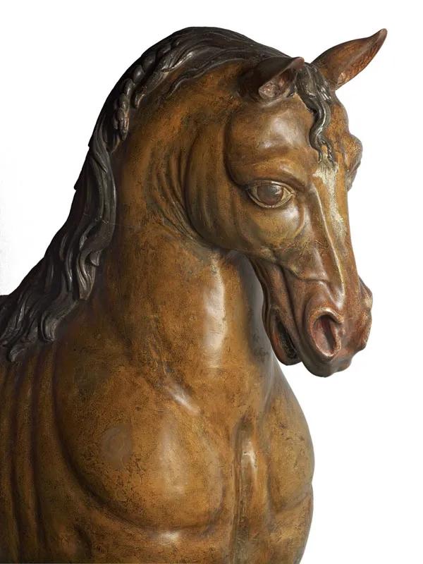 A carved oak horse with a brown coat and white flash on the muzzle.
