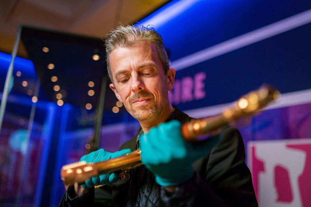Jonathan Ferguson holding gold AK47 for RE:Loaded exhibition launch 