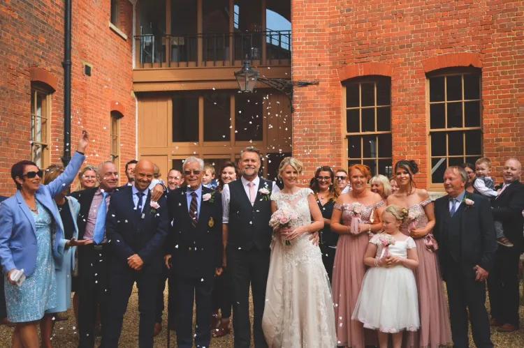 group photo of a wedding party set in the courtyard of Fort Nelson