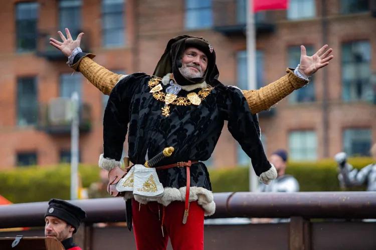Andy Deane at jousting event posing in front of the crowd with arms out