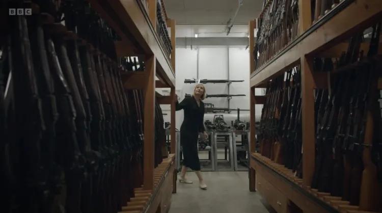 Lucy Worsley looking at gun racks during filming of Killing Sherlock
