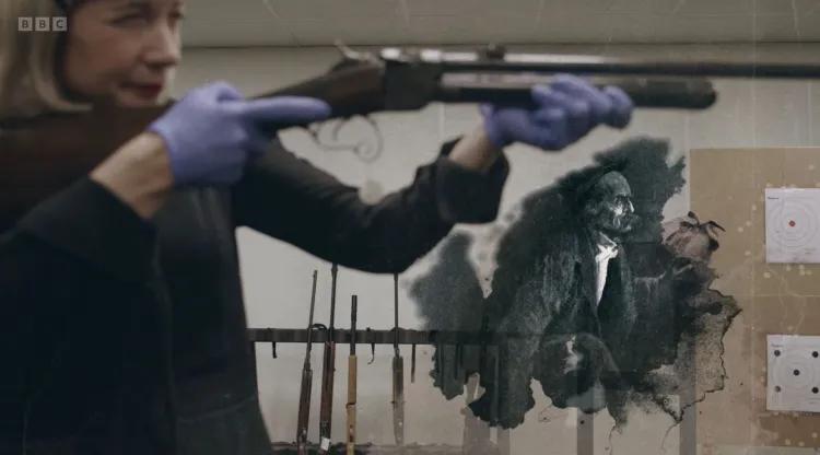 Lucy Worsley aiming a firearm with illustration of Sherlock Holmes underneath barrel.