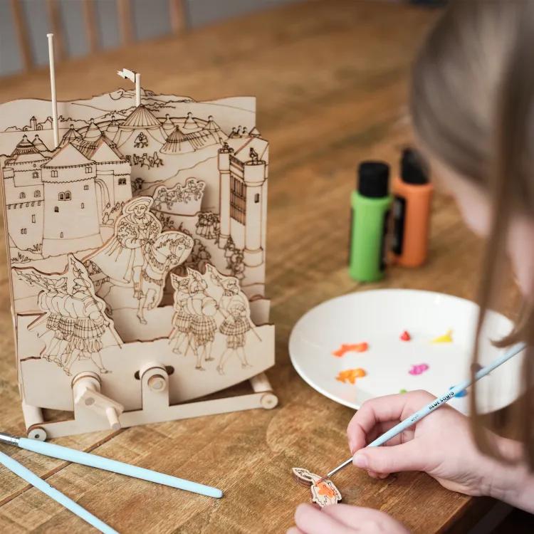 Child painting wooden scene of the Field of cloth of gold featuring Henry VIII