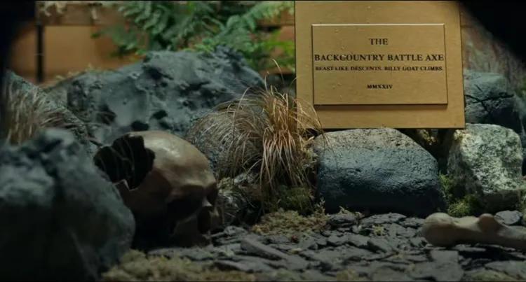 Plaque from Trek bikes promotion reading "back country battle axe" next to rockery, plants and a skull. 